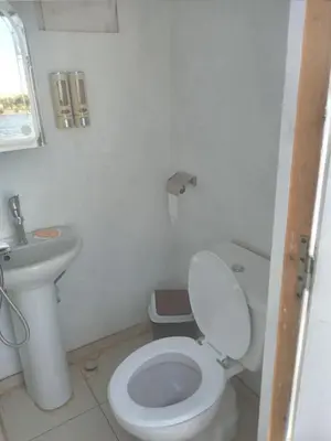 a white bathroom with a toilet and a sink at Mama Africa Felucca in Aswan