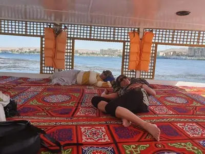 a group of people laying on the bed of a boat at Mama Africa Felucca in Aswan