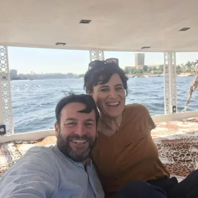 a man and woman sitting on the back of a boat at Mama Africa Felucca in Aswan