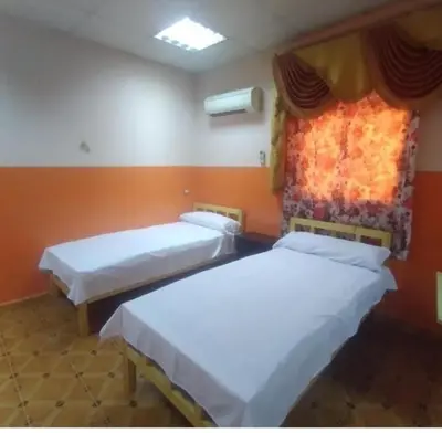 two beds in a room with a window at Ali Toot in Luxor