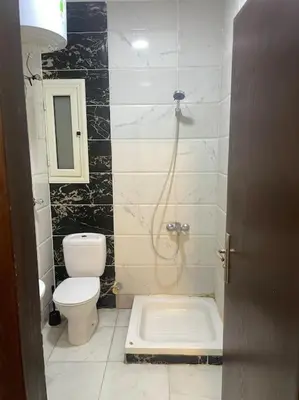 a bathroom with a toilet and a shower in it at Beach Side 1 Bedroom Apartment in Hurghada