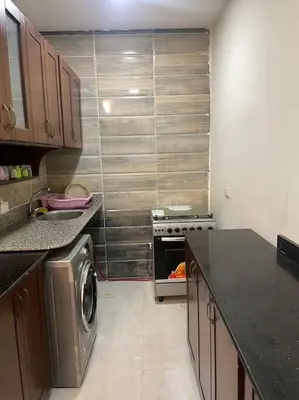 a small kitchen with a washer and dryer in it at Beach Side 1 Bedroom Apartment in Hurghada