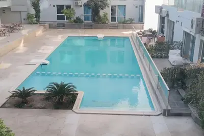 a large swimming pool in a courtyard with a building at Cozy 1 bedroom Seaview escape in Hurghada