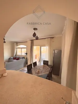a kitchen and living room with a table and a couch at Astonishing Twin Villa in O-C in Coraya Bay
