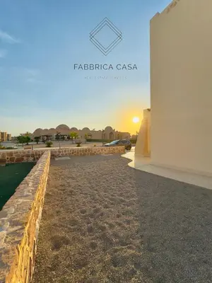 a view of a building with the sunset in the background at Astonishing Twin Villa in O-C in Coraya Bay