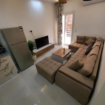 a living room with a large couch and a table at Hurghada Airport Aparthotel - SAHLHOMES in Hurghada