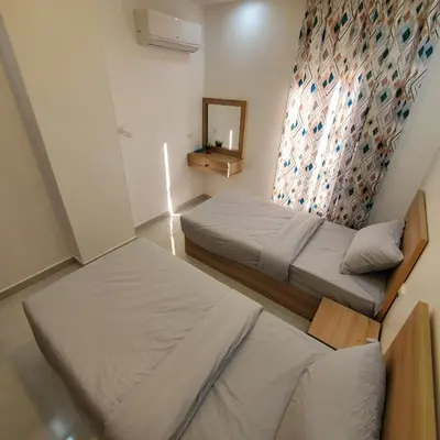 two beds in a small room with a mirror at Hurghada Airport Aparthotel - SAHLHOMES in Hurghada