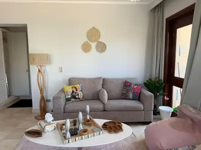 a living room with a couch and a table at The Charming Beachfront Retreat in Fanadir in Hurghada