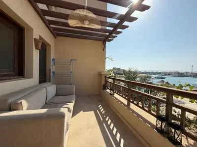a balcony with a couch and a view of the water at The Charming Beachfront Retreat in Fanadir in Hurghada