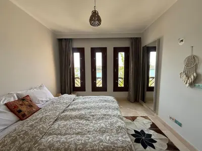 a bedroom with a large bed and windows at The Charming Beachfront Retreat in Fanadir in Hurghada