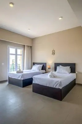 a bedroom with two beds and a window at Ocean View: Spacious 2-Bed Apt in Hurghada