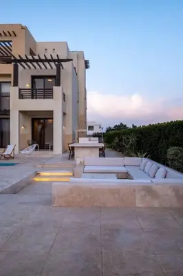 a building with a table and a bench in front of it at Luxury 4BR + Nanny Villa • Ancient Sands in Hurghada