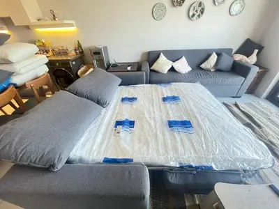 a living room with a bed covered in plastic at Chic Cyan 3BR Apt. • Prime Location in Hurghada