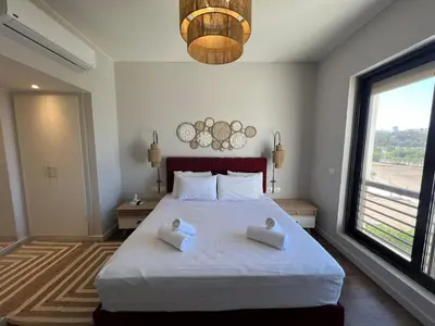 a bedroom with a large bed with two pillows on it at Chic Cyan 3BR Apt. • Prime Location in Hurghada