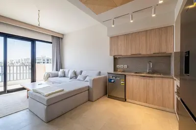 a living room with a couch and a kitchen at Freshly Minted: 1BR Fanadir Marina in Hurghada
