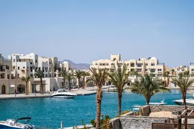 a view of a river with palm trees and buildings at Freshly Minted: 1BR Fanadir Marina in Hurghada