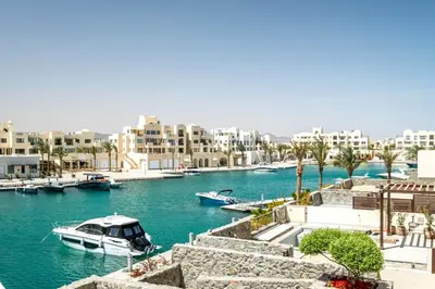 a boat is docked in a river with buildings at Freshly Minted: 1BR Fanadir Marina in Hurghada