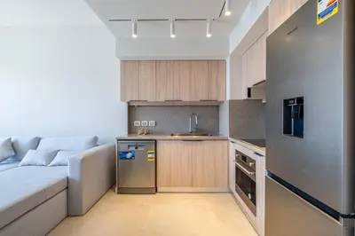 a living room with a couch and a kitchen at Freshly Minted: 1BR Fanadir Marina in Hurghada