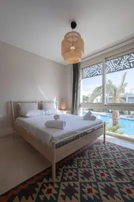 a bedroom with a bed and a large window at Newly Furnished & Bright 2BR Apt: Mangroovy in Hurghada