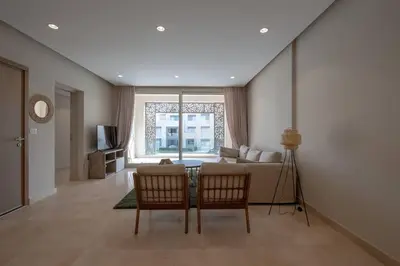 a living room with a couch and a table and chairs at Newly Furnished & Bright 2BR Apt: Mangroovy in Hurghada