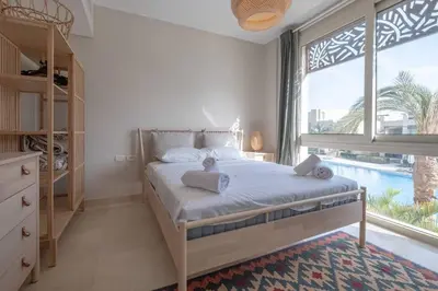 a bedroom with a bed and a large window at Newly Furnished & Bright 2BR Apt: Mangroovy in Hurghada