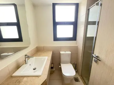 a bathroom with a sink and a toilet and two windows at Shedwan 2 Bdr Ground Floor in Hurghada