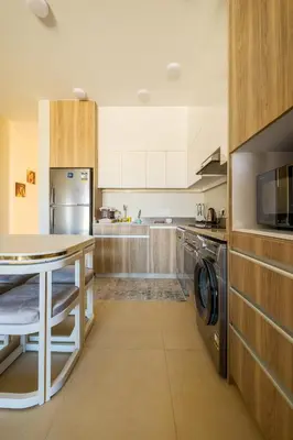 a large kitchen with a table and a microwave at Shedwan 2 Bdr Ground Floor in Hurghada
