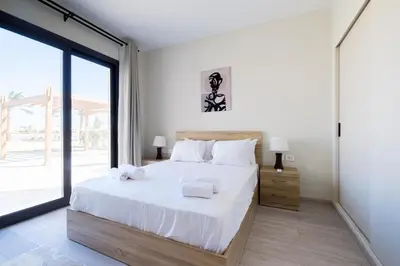 a bedroom with a large bed and a large window at Shedwan 2 Bdr Ground Floor in Hurghada