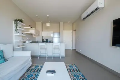 a living room with a couch and a kitchen at Chic Tawila 1BR • Pristine & Modern in Hurghada