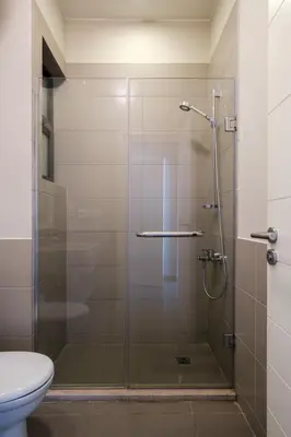 a bathroom with a glass shower with a toilet at Chic Tawila 1BR • Pristine & Modern in Hurghada