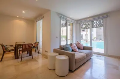 a living room with a couch and a table at Stylish 1BR • Scarab Main Pool Access in Hurghada