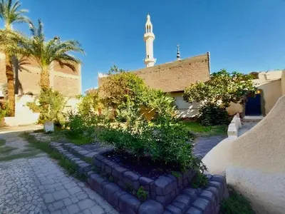 a building with a clock tower in the background at Osiris Hotel Luxor \u60a8\u5728\u76e7\u514b\u7d22\u7684\u7b2c\u4e8c\u500b\u5bb6 in Luxor