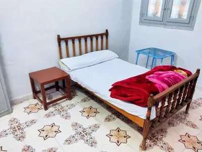 a bedroom with a bed with a wooden frame and a table at Osiris Hotel Luxor \u60a8\u5728\u76e7\u514b\u7d22\u7684\u7b2c\u4e8c\u500b\u5bb6 in Luxor