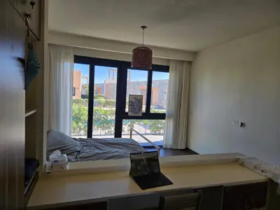 a room with a desk and a window with a bed at Somabay Beach House BW in Hurghada