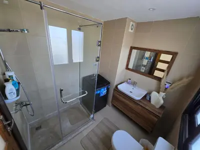 a bathroom with a shower and a toilet and a sink at Somabay Beach House BW in Hurghada