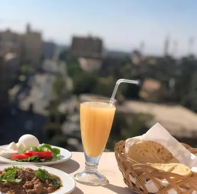 a table with plates of food and a glass of orange juice at Grand Memphis Hotel in Luxor in Luxor