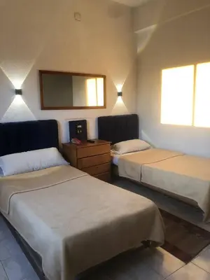 a hotel room with two beds and a mirror at Grand Memphis Hotel in Luxor in Luxor