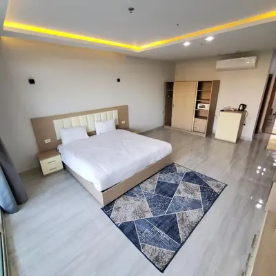 a bedroom with a large white bed and a rug at HRG Hurghada Hotel Apartments Aqua park - By MAMO Property in Hurghada