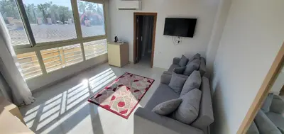 a living room with a couch and a tv at HRG Hurghada Hotel Apartments Aqua park - By MAMO Property in Hurghada