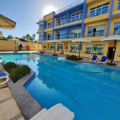 a large swimming pool in front of a building at HRG Hurghada Hotel Apartments Aqua park - By MAMO Property in Hurghada