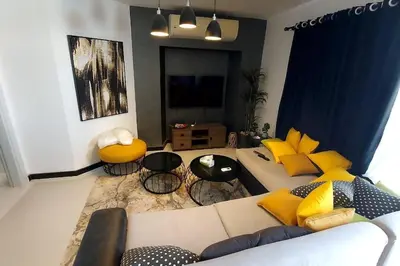 a living room with a couch and yellow pillows at Modern chalet at el gouna Swan Lake compound with Swimable lagoon view in Hurghada