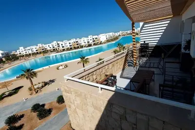 a view of a swimming pool next to a beach at Modern chalet at el gouna Swan Lake compound with Swimable lagoon view in Hurghada