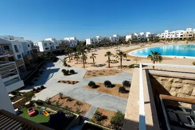 an aerial view of a resort with a pool and a beach at Modern chalet at el gouna Swan Lake compound with Swimable lagoon view in Hurghada