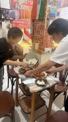 a couple of people preparing food on a table at Grand Square Hostel Luxor in Luxor