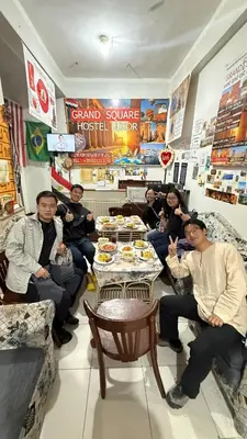 a group of people sitting around a table in a restaurant at Grand Square Hostel Luxor in Luxor