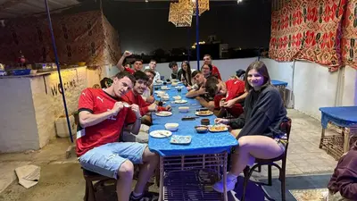 a group of people sitting at a table eating food at Grand Square Hostel Luxor in Luxor