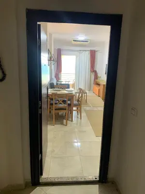 a door to a dining room with a table and a kitchen at Quiet quarter and private beach in Hurghada