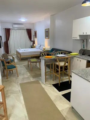 a kitchen and living room with a bed in the background at Quiet quarter and private beach in Hurghada