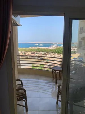 a room with a balcony with a view of the ocean at Quiet quarter and private beach in Hurghada