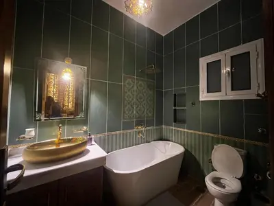 a bathroom with a tub and a sink and a toilet at Amenti House - Private Villa & Retreat Center in Luxor